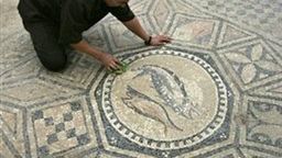 Więzień czyści odkrytą mozaikę z motywem ryb