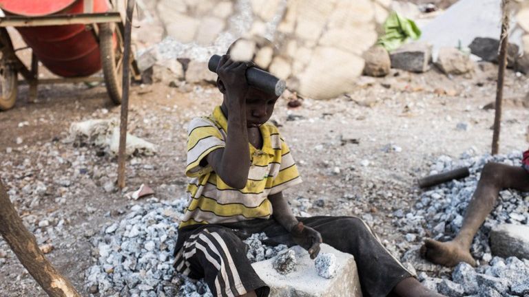 Mały chłopiec rozbija kamienie w kamieniołomie Ouagadougou w Burkina Faso