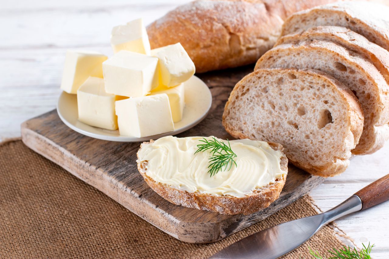 Fresh bread and homemade butter on a white wooden table