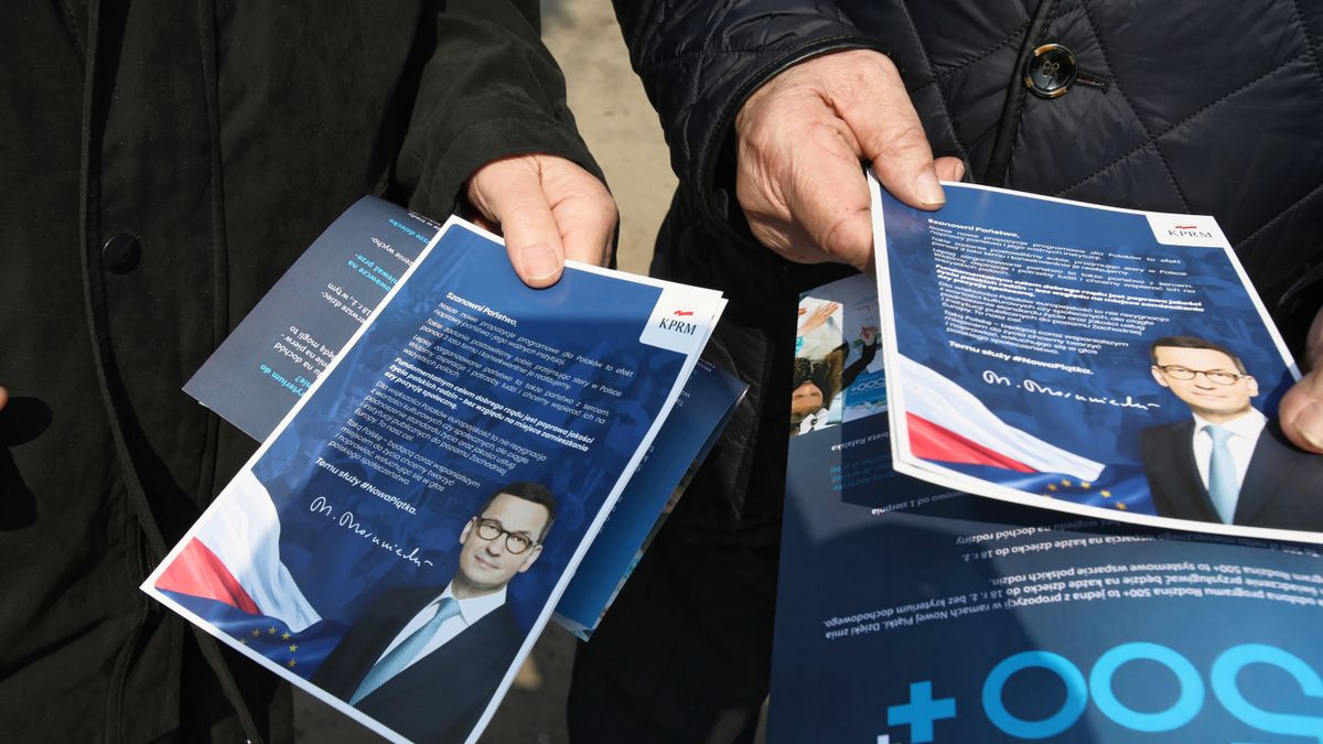 Mieszkańcy Otwocka z ulotkami reklamującymi nowe programy socjalne rządu.