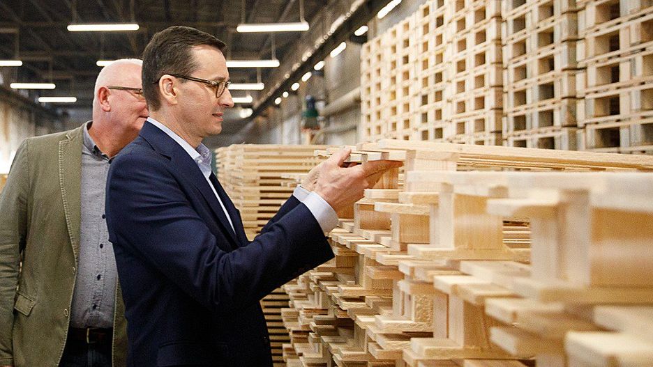 Mateusz Morawiecki ogląda europalety wyprodukowane w Zagnańsku
