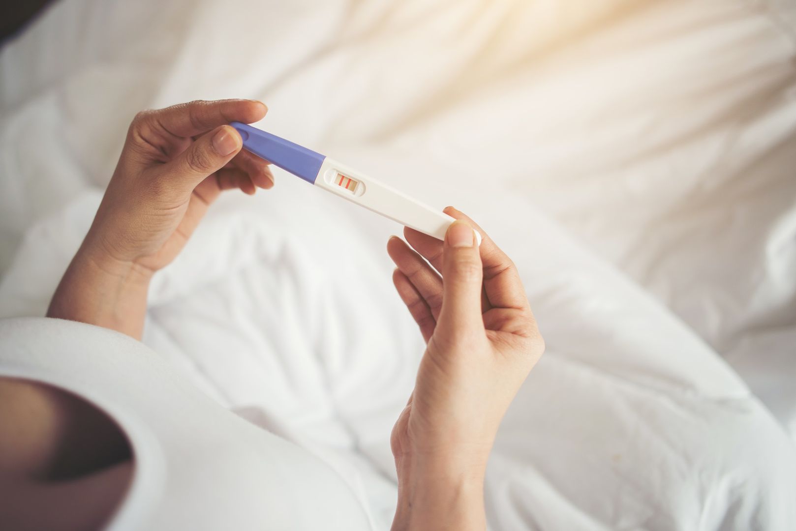 Young woman hand holding pregnancy test 