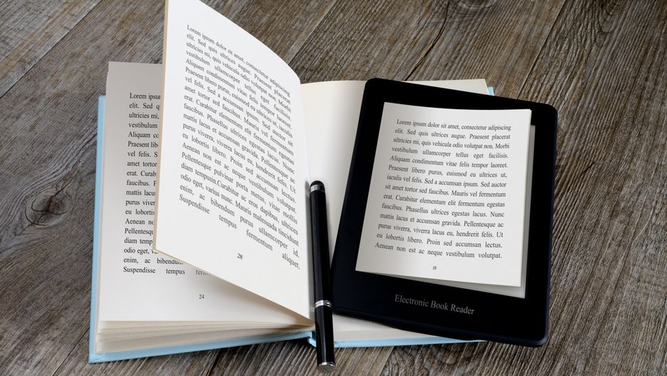 modern ebook reader on book on wooden table