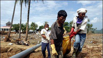 Wolontariusze niosa zwloki jednej z ofiar