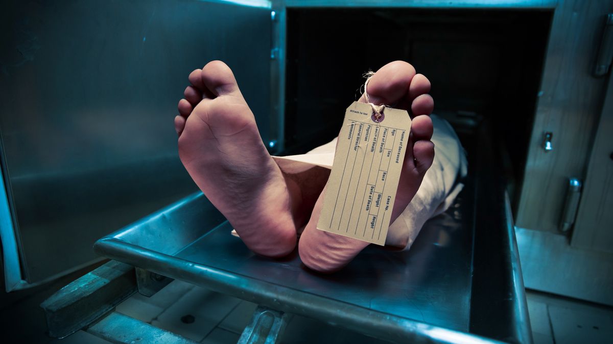 Grungy photo of feet with toe tag on a morgue table