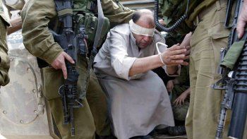 Izraelscy żołnierze prowadzą pojmanego Palestyńczyka z obozu dla uchodźców Rafah