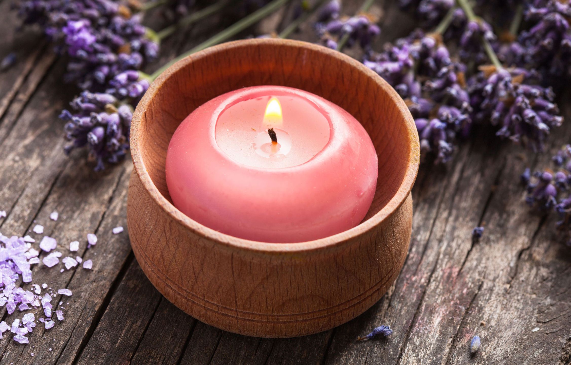56628304 - sprig of fragrant lavender alongside a burning aromatic candle 