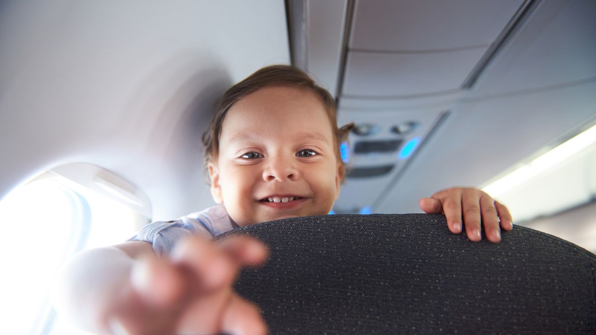 Smiling little boy travel  in airlane. Child air plane passenger