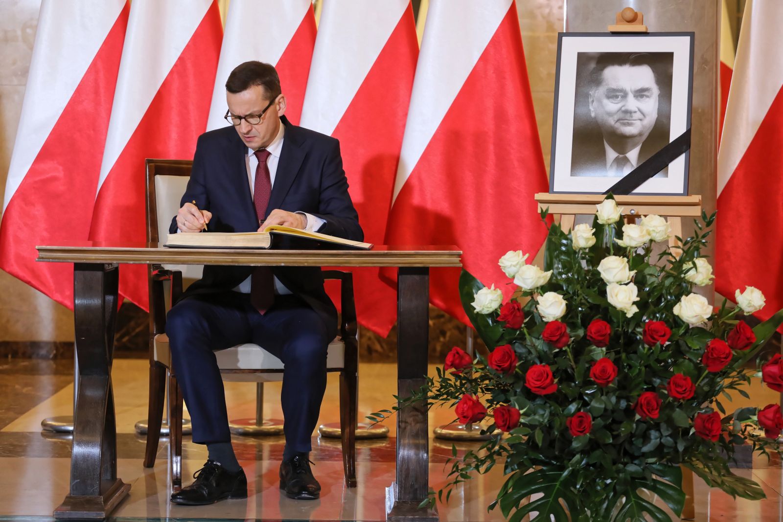 Premier Mateusz Morawiecki wpisuje się do księgi kondolencyjnej, wystawionej w KPRM po śmierci Jana Olszewskiego.