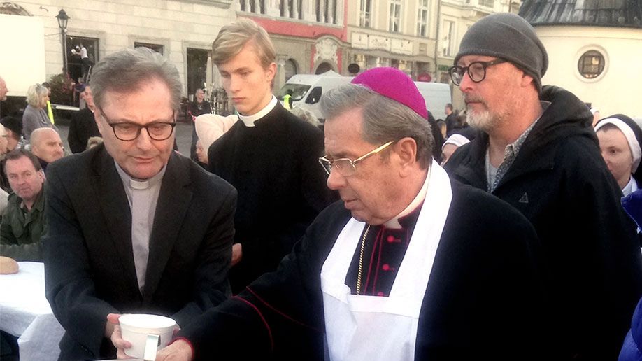 Karmienie głodnych na rynku w Krakowie. Na pierwszym planie Janusz Gajos, za nim reżyser Wojtek Smarzowski