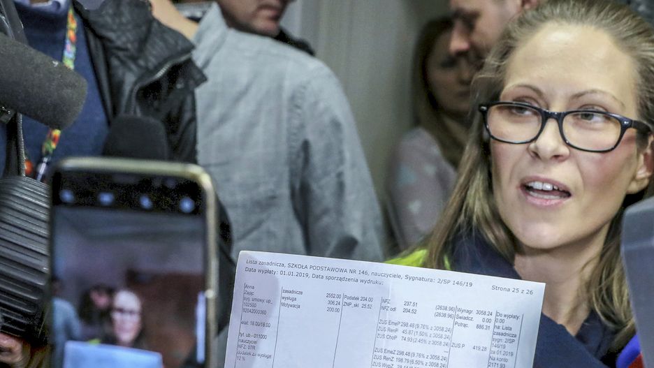 Anna Zając tłumaczy, dlaczego nauczyciele będą strajkować. Prezentuje zestawienie swoich wynagrodzeń. Ma potrójny tytuł magistra, w szkole uczy j. angielskiego. Zarabia niecałe 2200 zł na rękę. Jest członkiem ZNP.