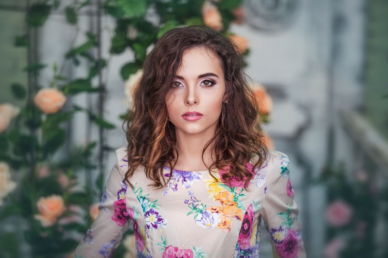 Beautiful woman model in the colors of the roses with a beautiful makeover in the garden 