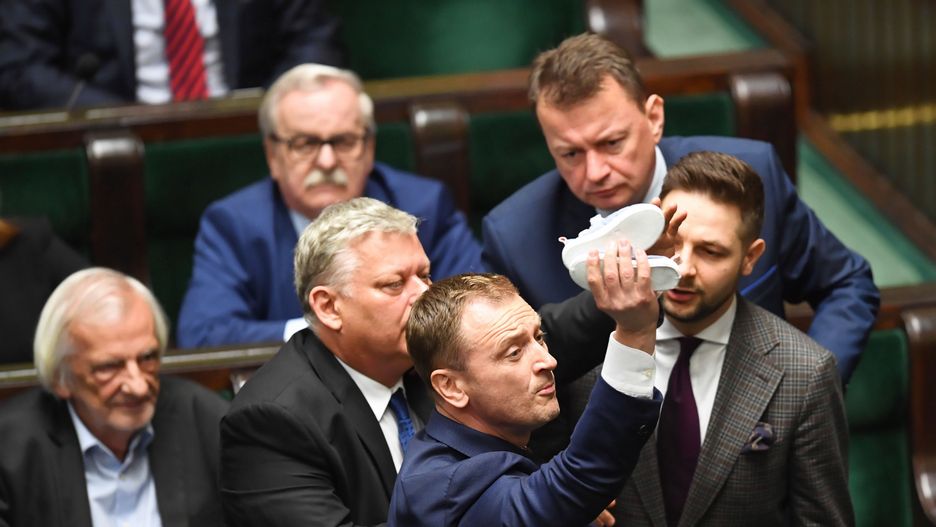 Posiedzenie Sejmu. 16 maja 2019 roku. Poseł PO Sławomir Nitras usiłuje wręczyć dziecięce buciki Jarosławowi Kaczyńskiemu.