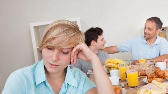 smutna kobieta przy stole z rodziną