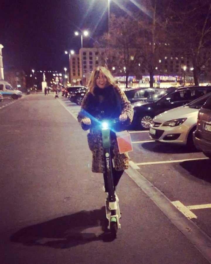 Karolina Szostak z torbą faworków jedzie na hulajnodze