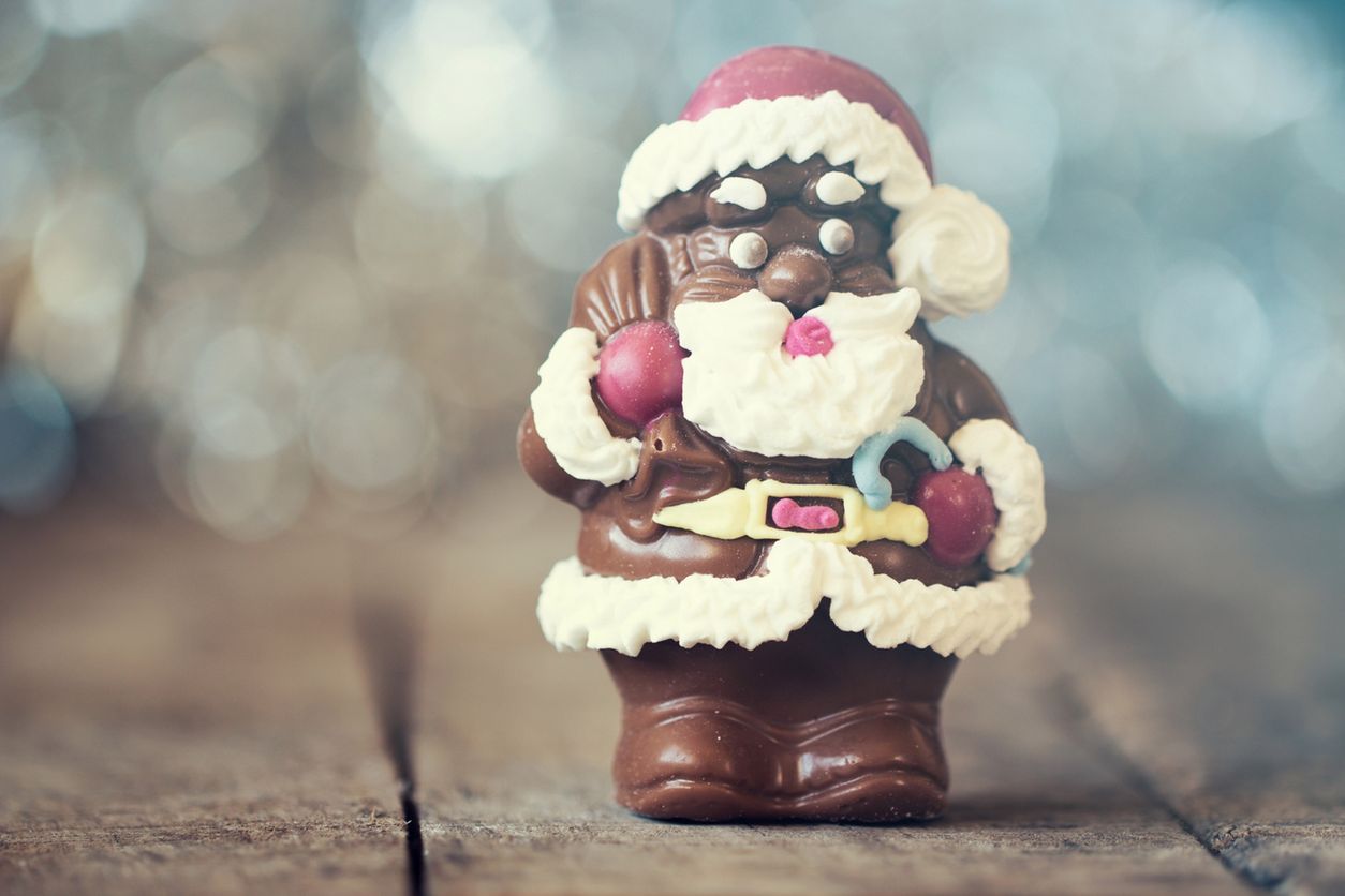 Chocolate Santa Claus with a bag on a old wooden background 