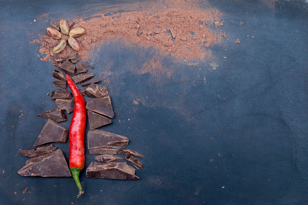 Christmas tree and comet made of chocolate and red chili pepper on a black background 