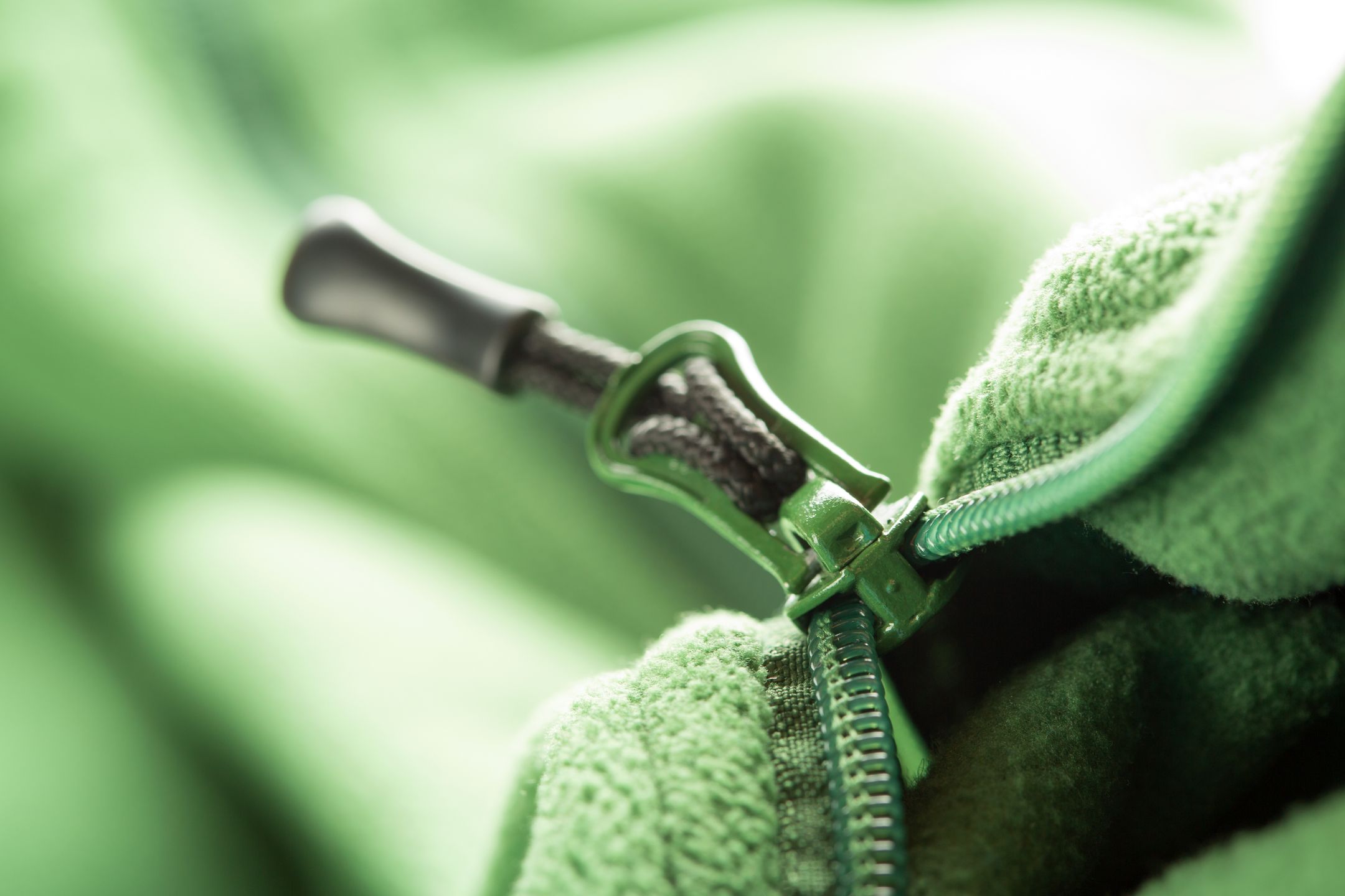 Closeup of zipper opening green fleece jacket 
