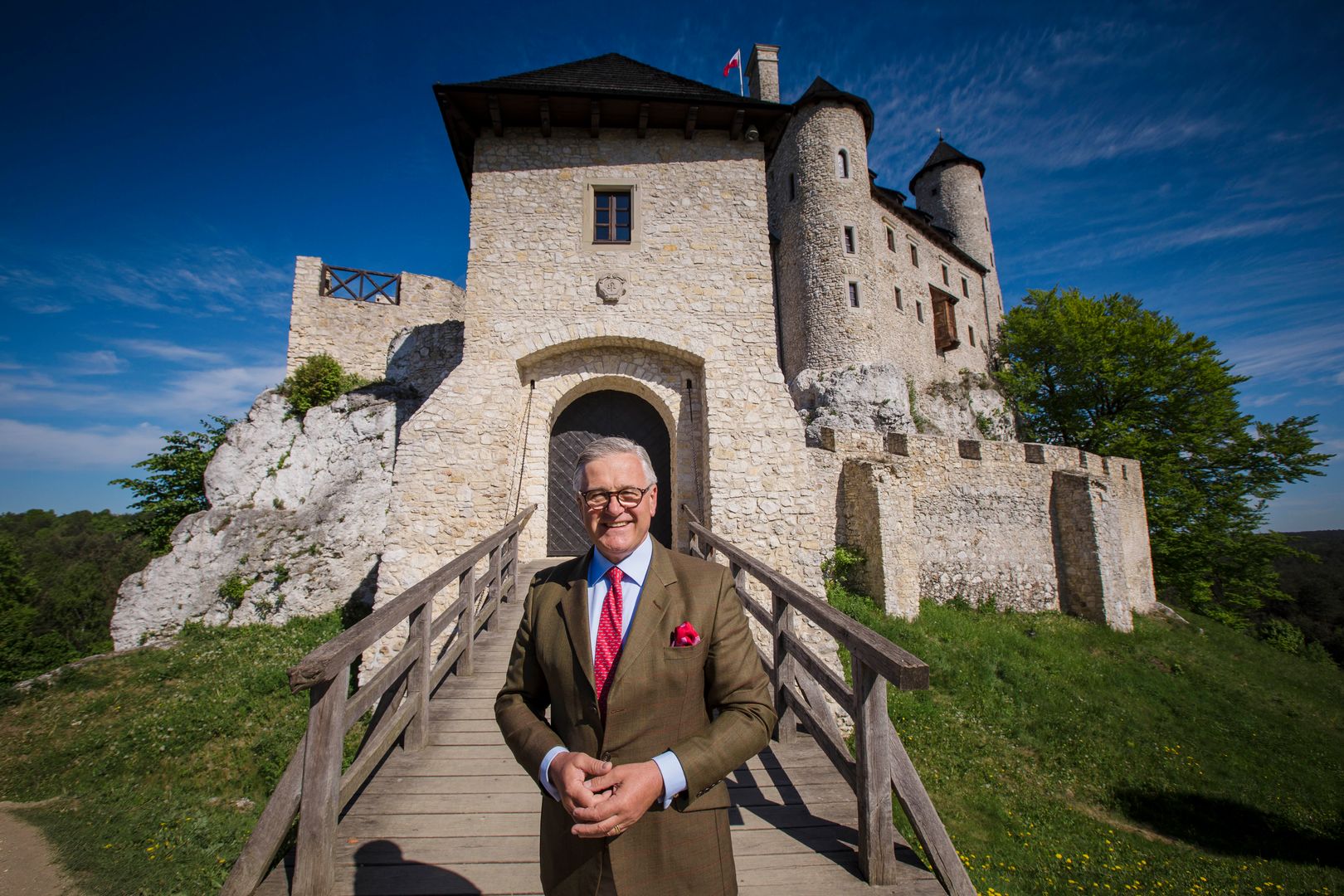Senator Jarosław W. Lasecki na tle zamku, który zrewitalizował