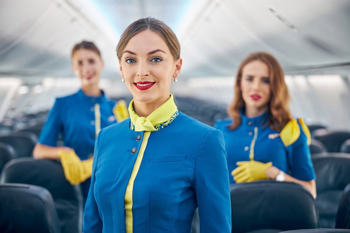 Dlaczego stewardessy trzymają ręce za plecami? Fot. Freepik