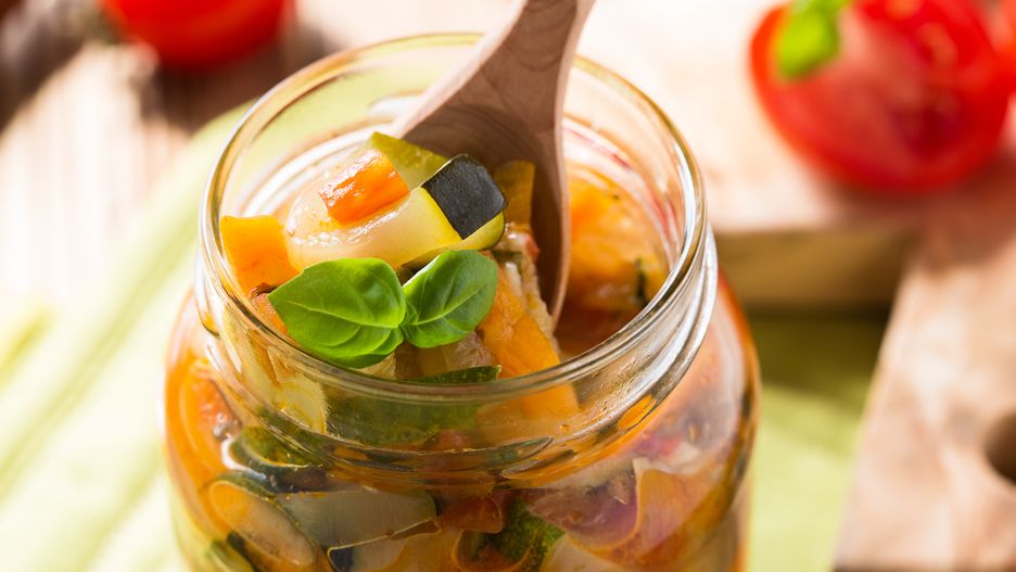 Homemade healthy vegetable  preserves in glass jar, zucchini, carrots, onions and tomatoes salad