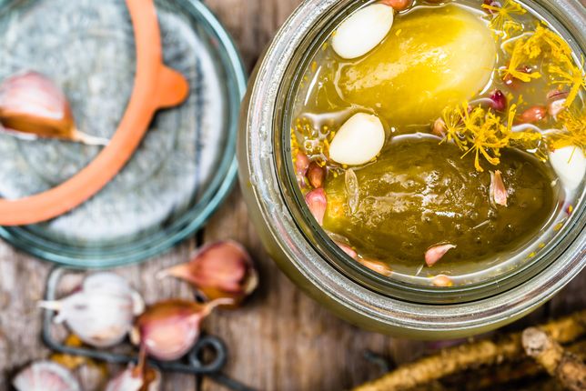 Homemade pickle with garlic and dill. Pickled gherkins in jar, closeup, top view. 