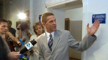 Długosz pokazuje tabliczkę, którą - jak powiedział dziennikarzom, będzie musiał zdjąć