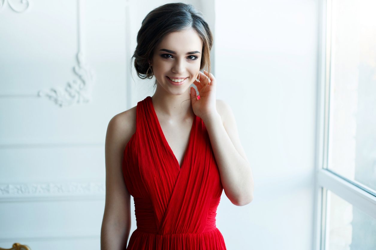 Portrait of Beautiful Sensual smilyng Woman in Fashion Red Dress. Christmas Sales and Shopping concept. Studio shot 