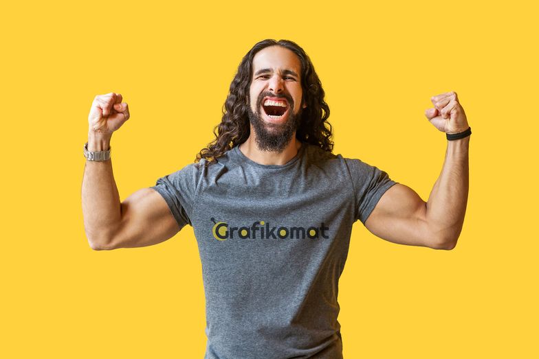 Yes! Portrait of happy rejoicing bearded young man with long curly hair in grey tshirt standing, raised arms and celebrating his victory, screaming . indoor studio shot isolated on yellow background.