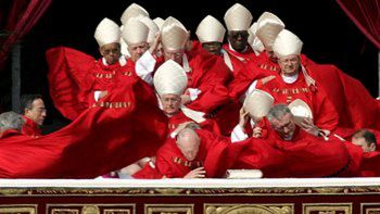 Silny wiatr przeszkadza kardynałom, kiedy całują ołtarz przed mszą pogrzebową