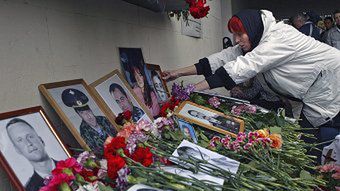 Kobieta ustawia portret bliskiej osoby w teatrze na Dubrowce.