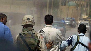 Iracki policjant i żołnierz USA prowadzą mężczyznę, aresztowanego tuz po zamachu