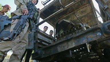 Amerykański żołnierz przy spalonej ciężarówce