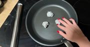 Połóż kulki z folii aluminiowej na rozgrzaną patelnię. Dzięki nim gotowanie będzie prostsze!