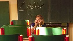 Nauczycielka za biurkiem w kompletnie pustej klasie