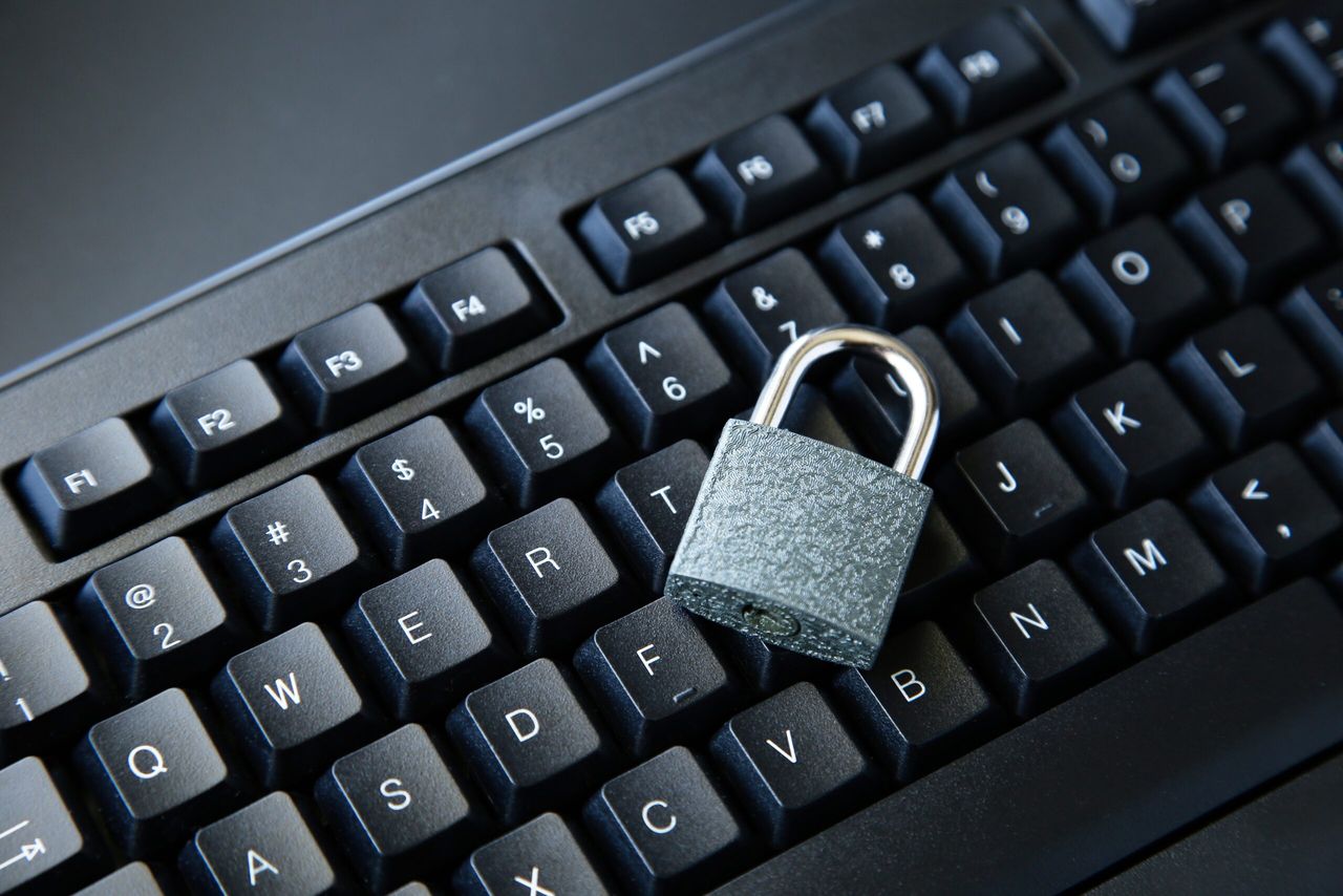 A high angle shot of a lock on a black computer keyboard on a black surface