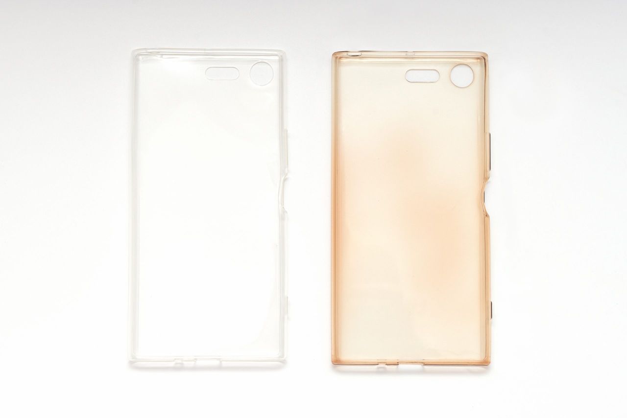 Silicone case on smartphone, damaged and brand new on white background, top view