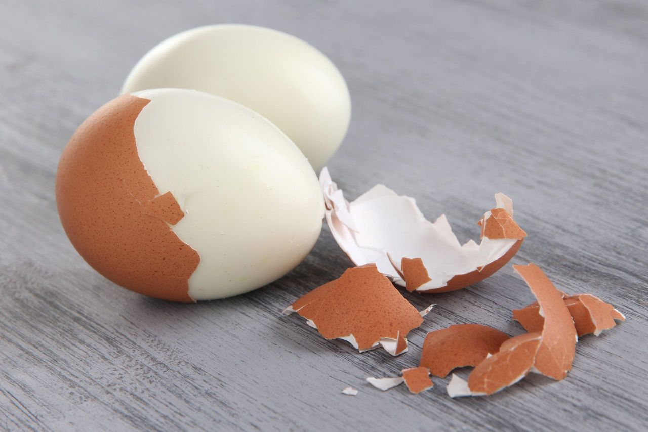 Peeled boiled egg on wooden background