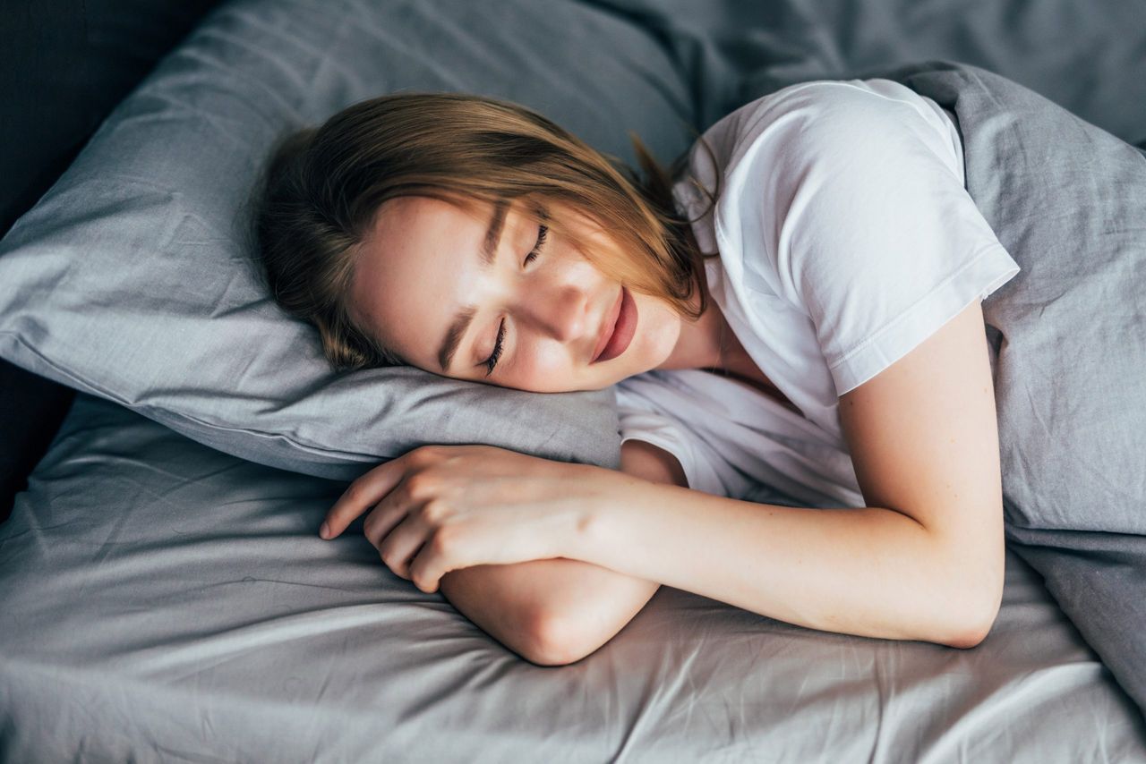 Woman sleeping. Beautiful young smiling woman sleeping in bed