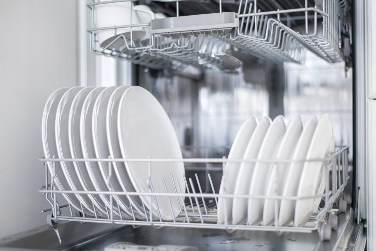 White flat plates large and small are loaded into the dishwasher