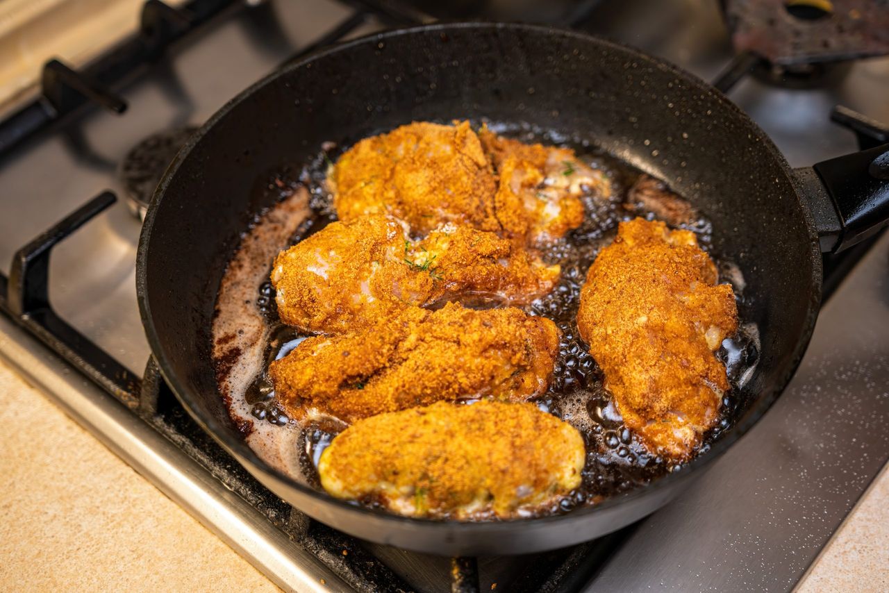 chicken cutlets on frying pan. style rustic. selective focus. The cooking process in a pan of fried meat chop in batter.