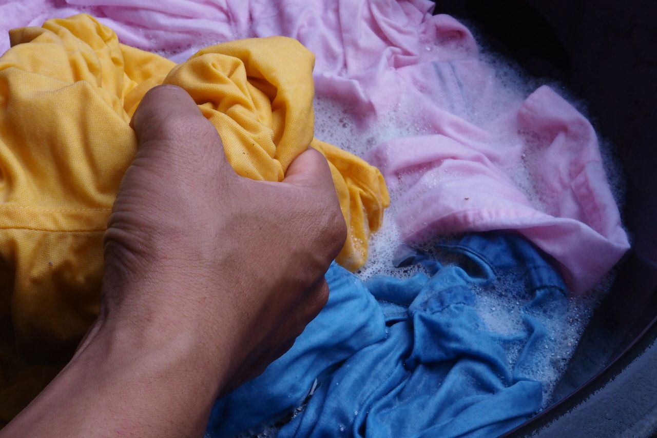 Hand washing Yellow,Pink,Blue shirt with bubble white basin.