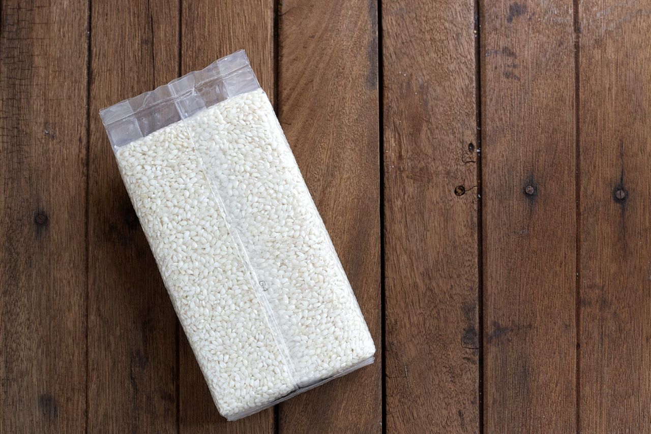 Arborio Risotto Rice pack short-grain on wooden table top, photographed
