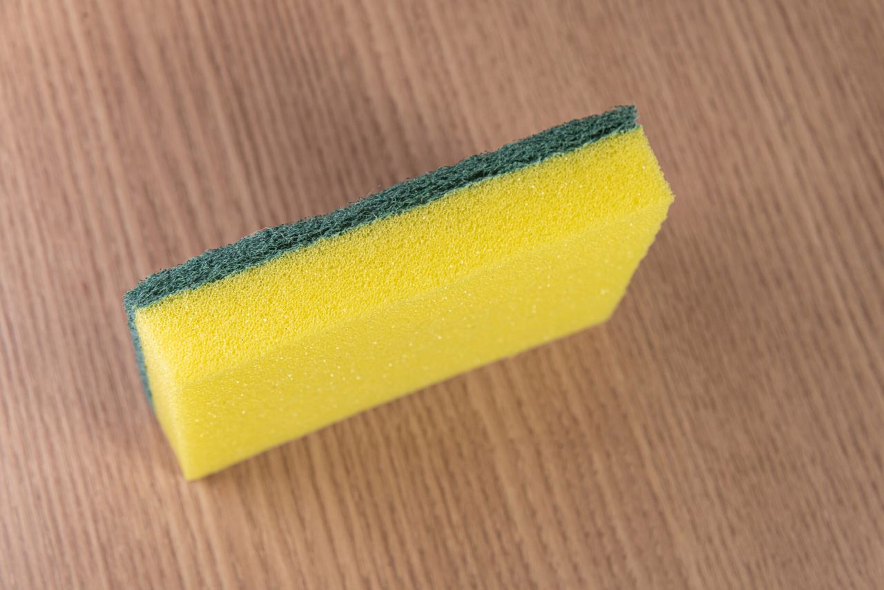 Kitchen sponge on the wooden background