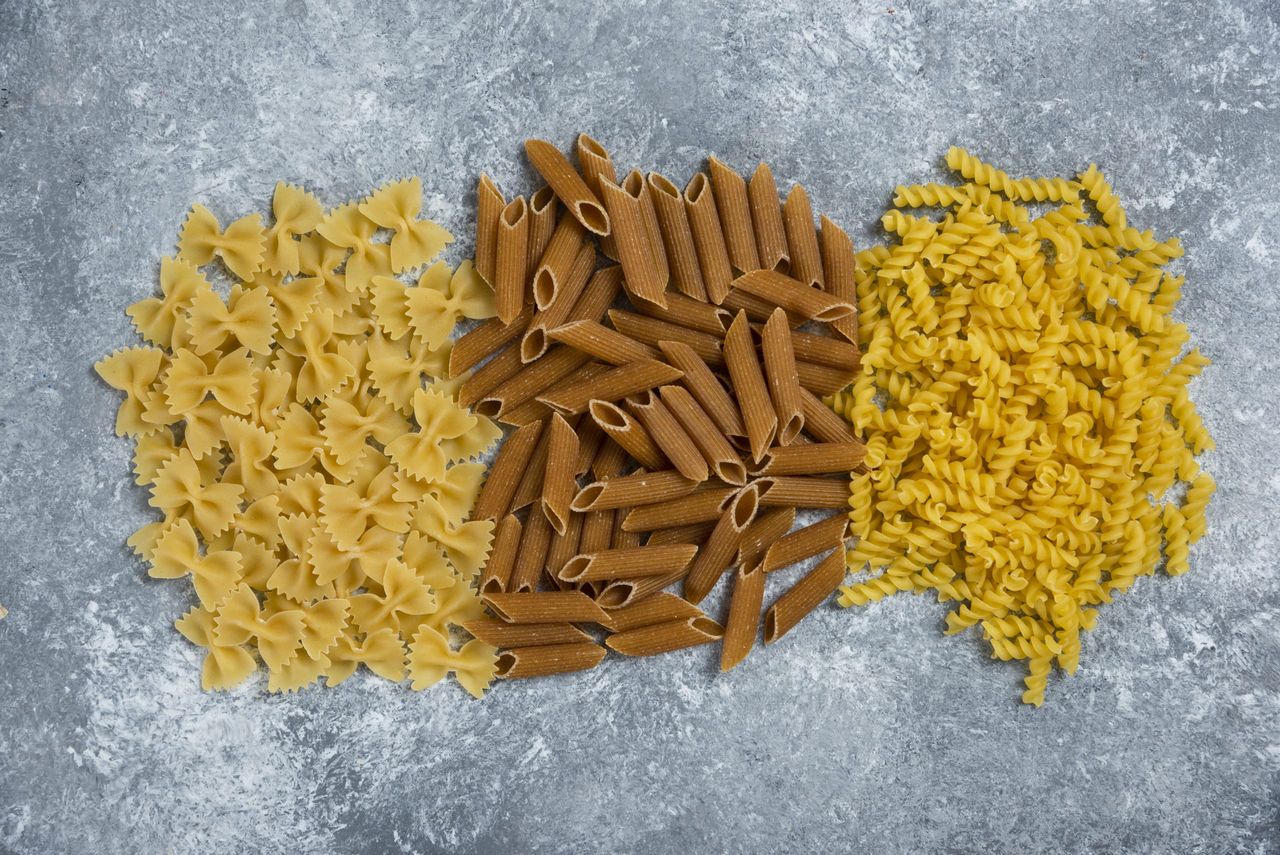 Different types of pasta on a gray background. High quality photo
