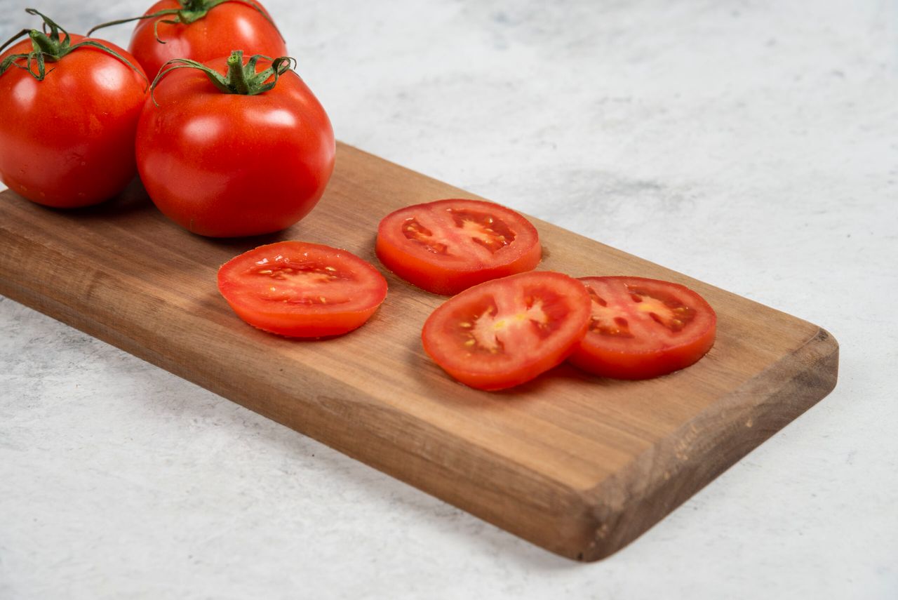 Fresh red tomatoes on a wooden cutting board . High quality photo
