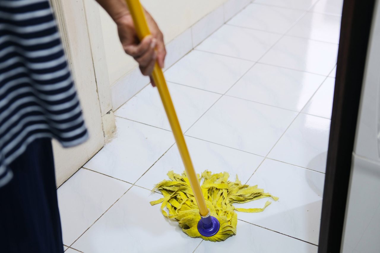 Person cleaning house by mopping the floor