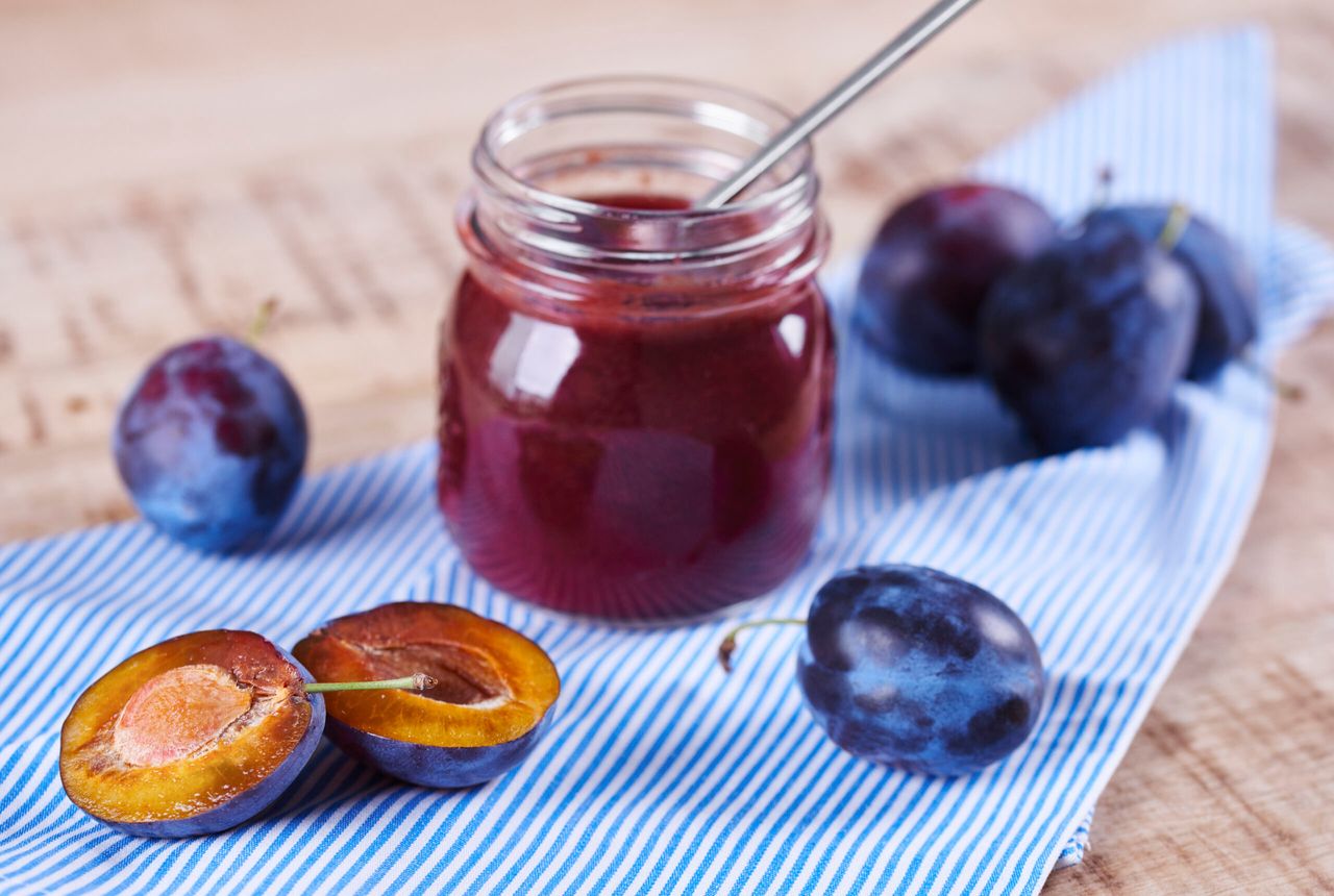 Homemade jar of plum jam with spoon