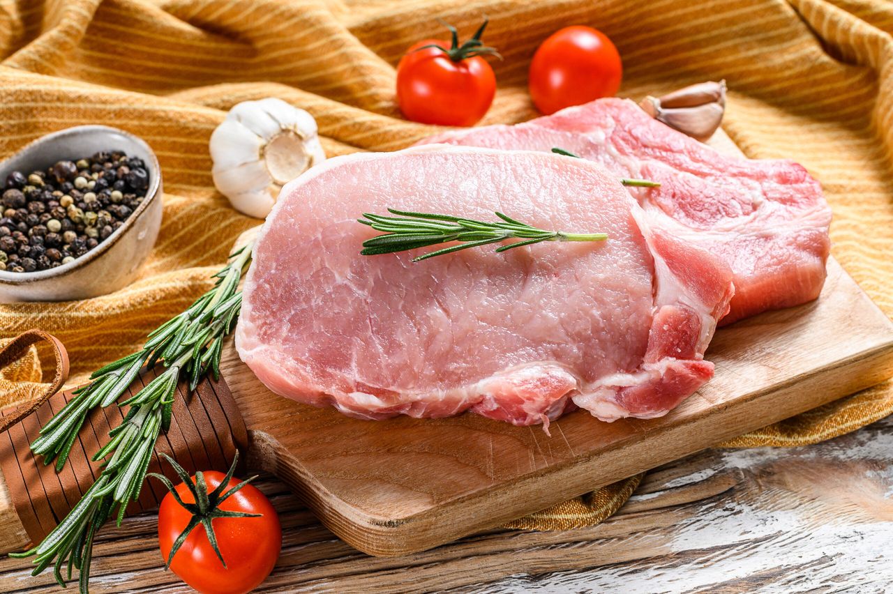 Raw pork rib chop steak. Organic meat. White wooden background. Top view.
