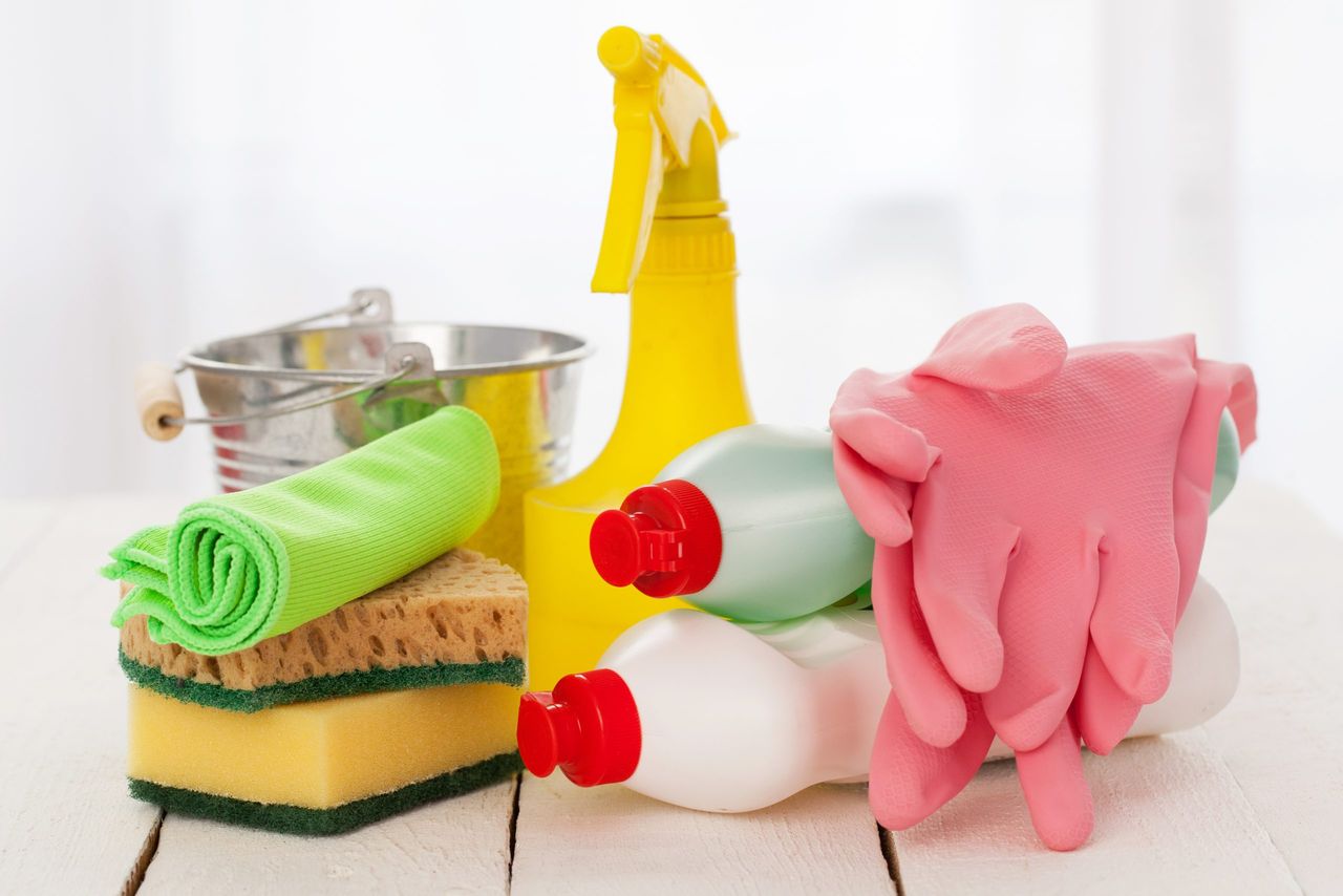 Bright colorful cleaning set on a white wooden table